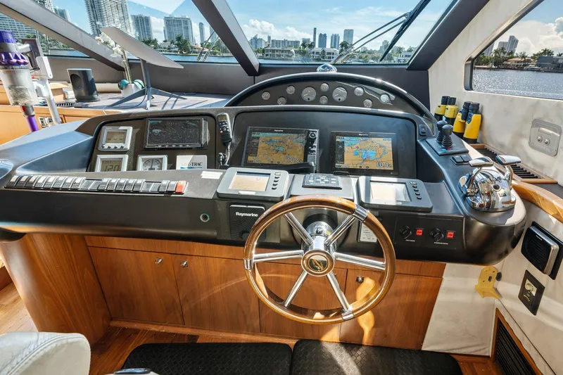 Slide: The Image of Helm of 2008 Sunseeker 90 Yacht with navigation equipment and city skyline view. - 82