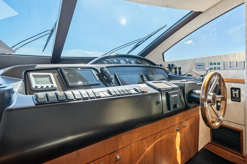 Slide: The Image of Control panel of a 2008 Sunseeker 90 Yacht with steering wheel and navigation instruments. - 83