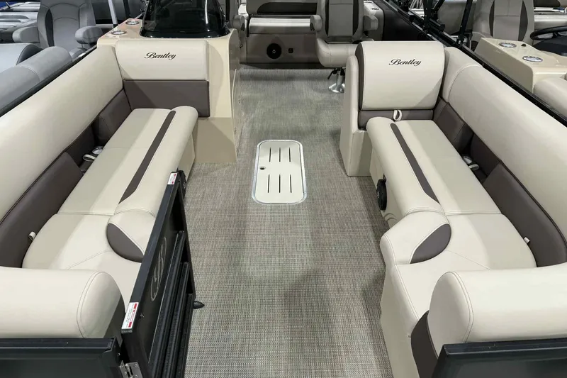 Slide: The Image of 2026 Bentley Pontoons Legacy 243 interior with beige seating and dual captain chairs. - 1