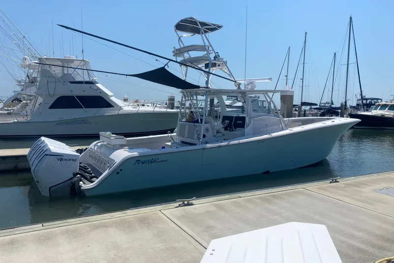 Slide: The Image of 2022 Front Runner 39 CC boat docked at marina, featuring twin outboard engines. - 2