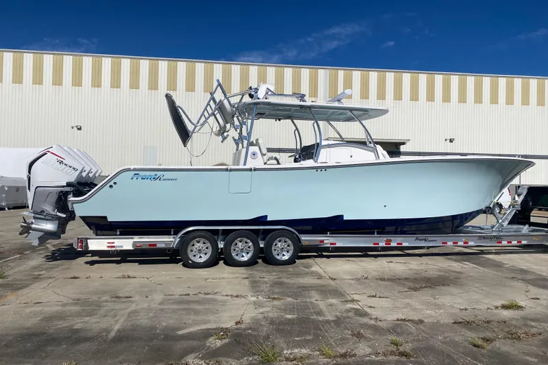 Slide: The Image of 2022 Front Runner 39 CC boat on trailer, parked outdoors near a warehouse. - 3