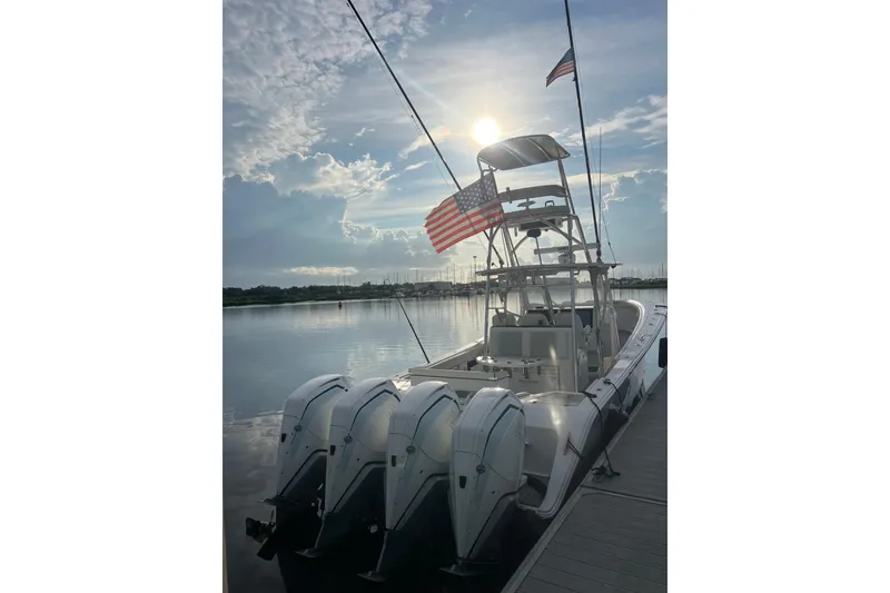 Slide: The Image of 2022 Front Runner 39 CC boat docked, featuring four engines and American flags, under a bright sky. - 5