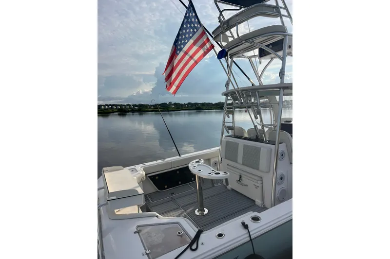Slide: The Image of 2022 Front Runner 39 CC boat with American flag, docked on calm water. - 51