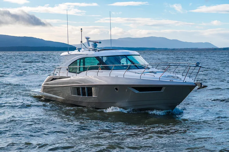 Slide: The Image of 2014 Cruisers Yachts 45 Cantius navigating scenic waters with mountainous backdrop. - 8