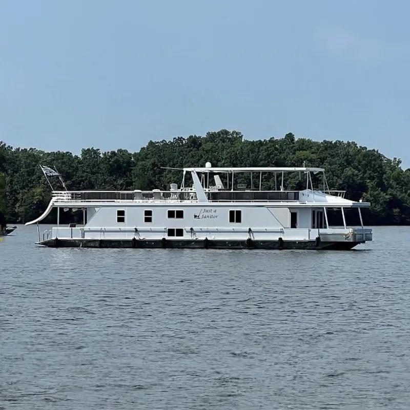The Image of 2023 Sumerset Custom 18 x 79 houseboat on a calm lake with forested background. - 0
