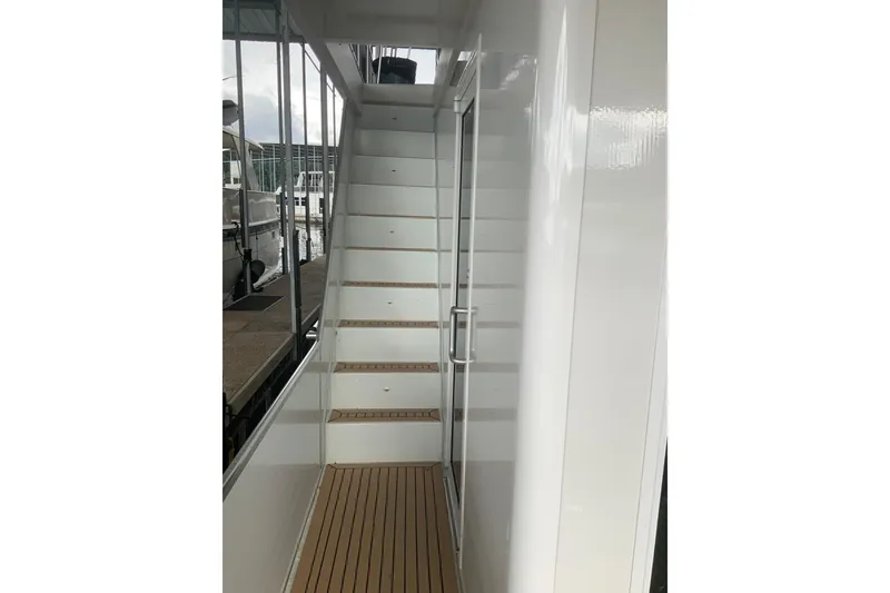 Slide: The Image of Staircase on 2023 Sumerset 18 x 81 houseboat with sleek white design. - 11