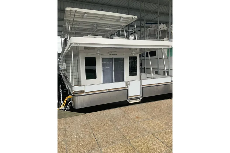 Slide: The Image of 2023 Sumerset 18 x 81 houseboat docked, featuring modern design and spacious deck. - 2