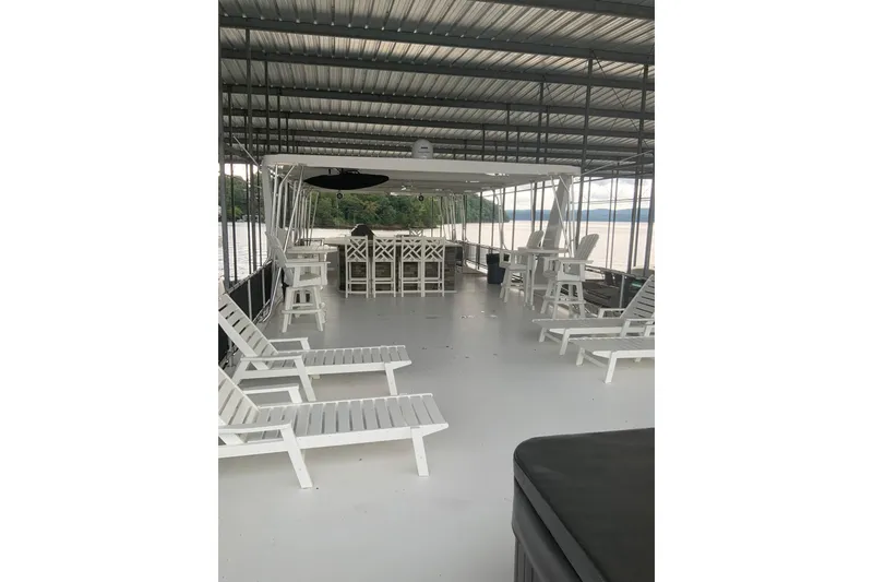 Slide: The Image of Rooftop deck of 2023 Sumerset 18 x 81 houseboat with white lounge chairs and bar area. - 28