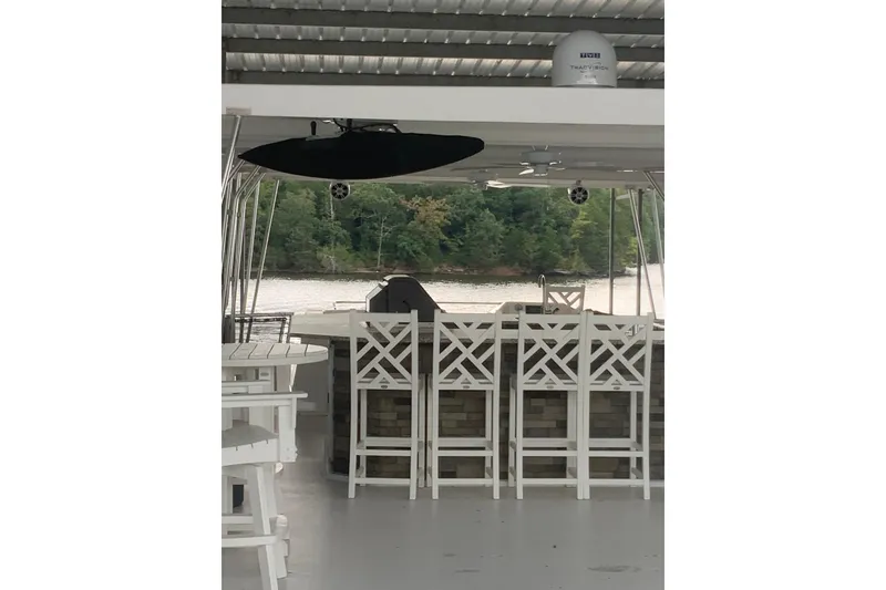 Slide: The Image of 2023 Sumerset 18 x 81 houseboat interior with bar stools and river view. - 30