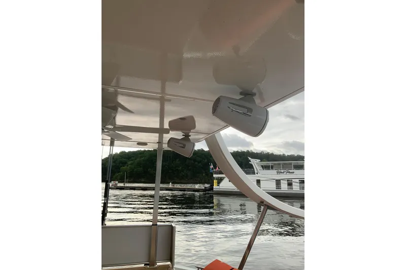 Slide: The Image of 2023 Sumerset 18 x 81 houseboat with outdoor speakers, docked by a scenic waterfront. - 31