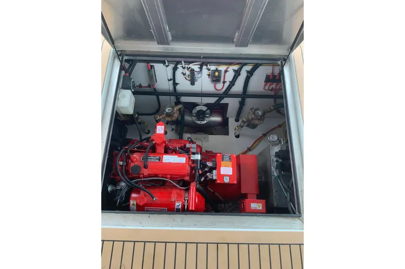 Slide: The Image of Engine compartment of 2023 Sumerset 18 x 81 houseboat, featuring red machinery and wiring. - 37