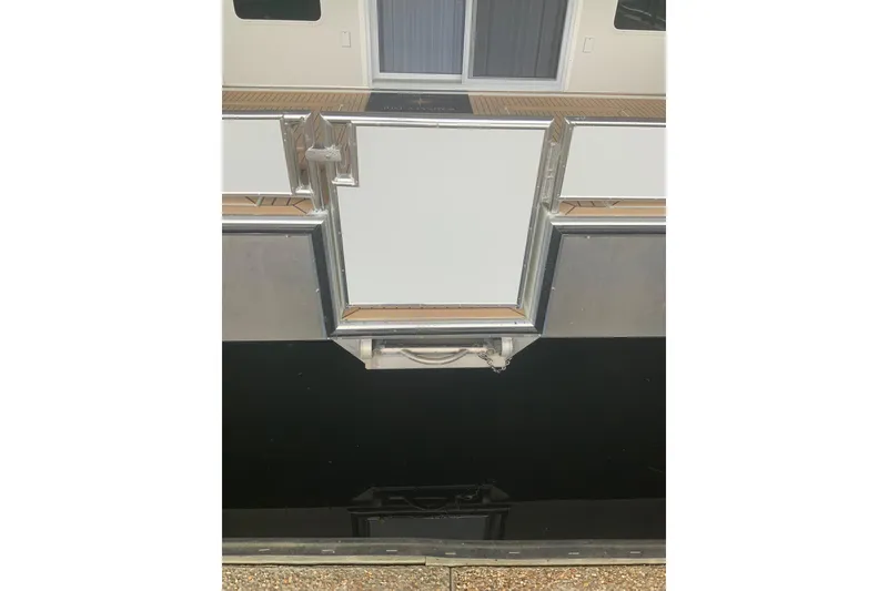 Slide: The Image of 2023 Sumerset 18 x 81 houseboat exterior with closed door and water reflection. - 4