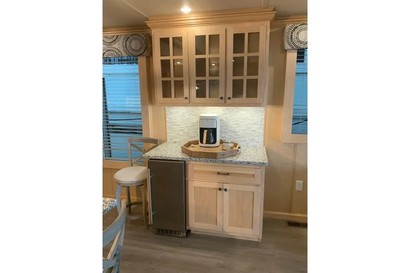 Slide: The Image of Modern kitchen corner in 2023 Sumerset 18 x 81 houseboat with cabinets and coffee maker. - 49