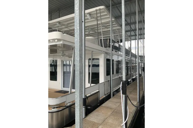 Slide: The Image of 2023 Sumerset 18 x 81 houseboat docked under covered marina. - 5