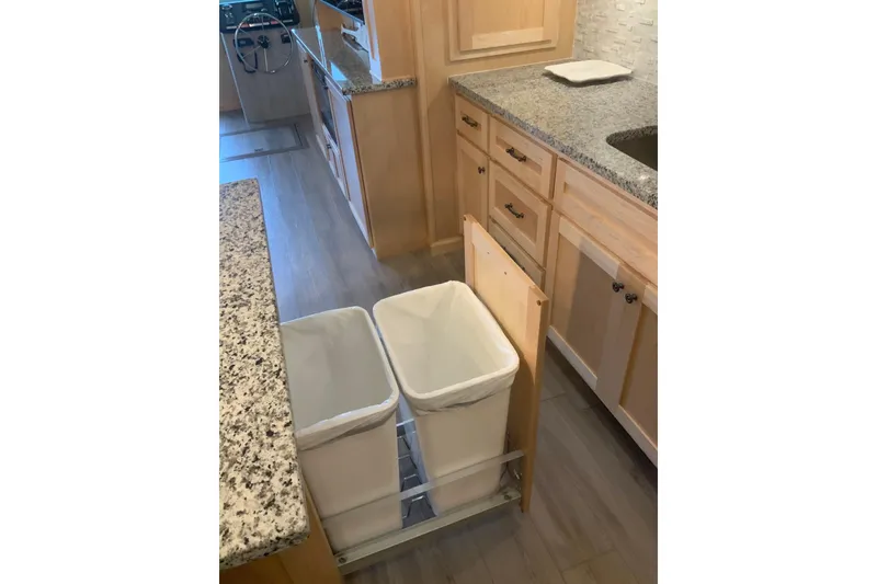 Slide: The Image of Pull-out trash bins in a modern Sumerset 18 x 81 houseboat kitchen, 2023 model. - 51