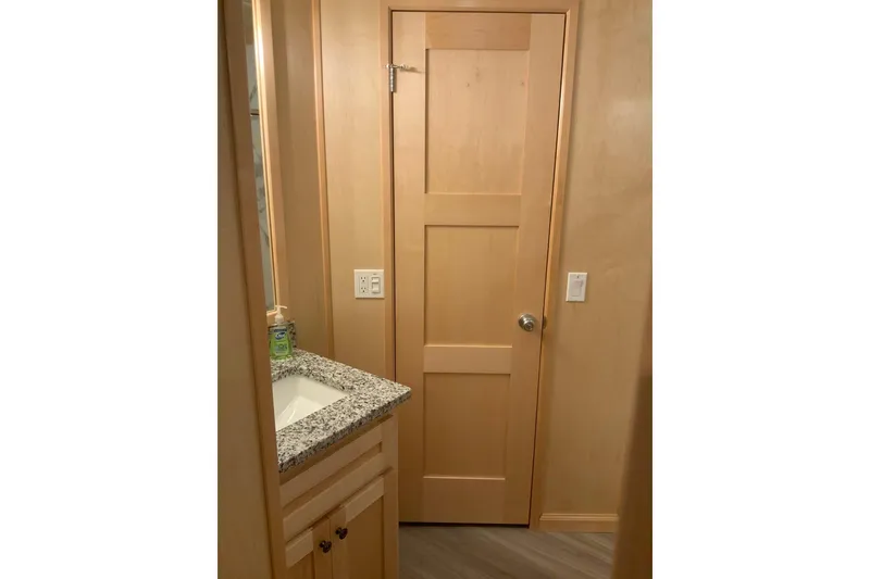 Slide: The Image of Modern bathroom in 2023 Sumerset 18 x 81 houseboat with granite countertop and wooden door. - 63