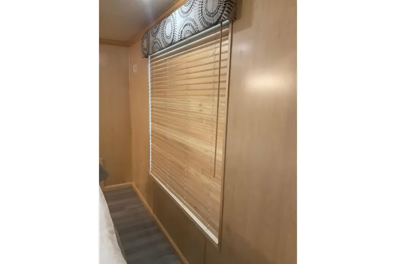 Slide: The Image of Interior of 2023 Sumerset 18 x 81 houseboat with wooden blinds and patterned valance. - 72