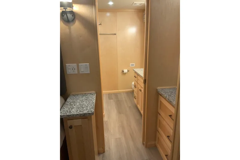 Slide: The Image of Modern bathroom interior in 2023 Sumerset 18 x 81 houseboat, featuring granite countertops and wooden cabinetry. - 76