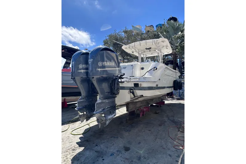 Slide: The Image of 2011 Robalo R300 Center Console boat with twin Yamaha engines on a sunny day. - 2