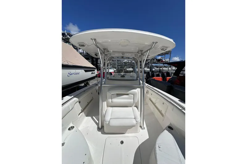 Slide: The Image of 2011 Robalo R300 Center Console boat with white seating and T-top under clear blue sky. - 25