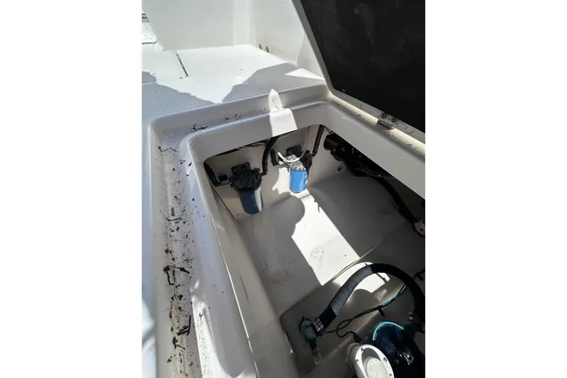 Slide: The Image of 2011 Robalo R300 Center Console boat compartment with visible filters and wiring. - 33
