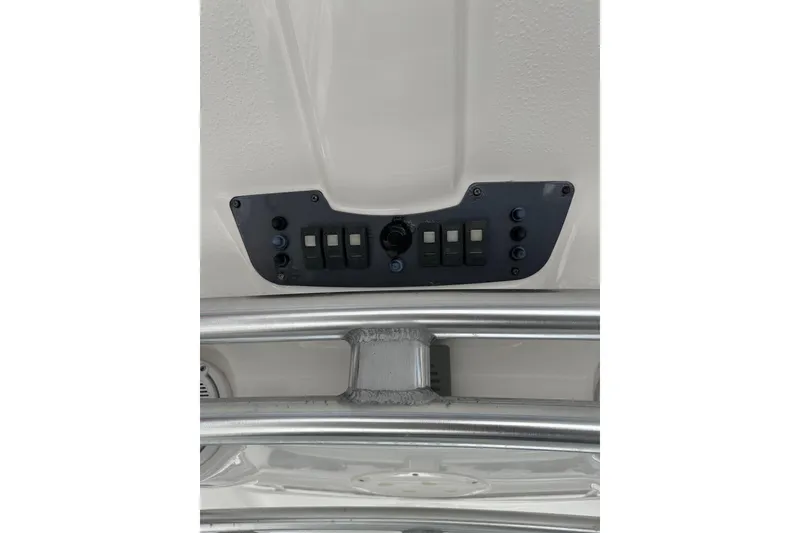 Slide: The Image of Control panel on 2011 Robalo R300 Center Console boat, featuring switches and metallic framework. - 37