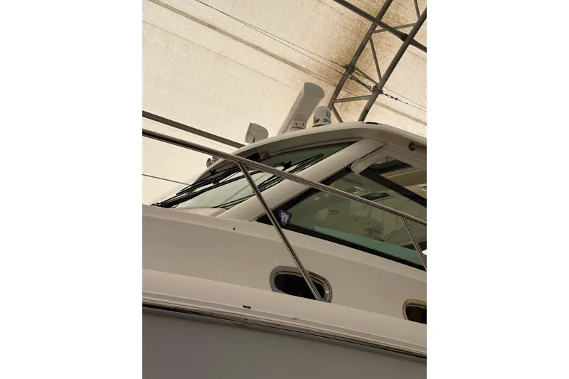 Slide: The Image of 2018 Boston Whaler 345 Conquest boat under a canopy, showcasing sleek design and structure. - 13