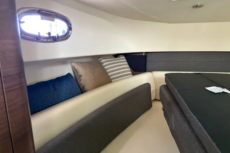 Slide: The Image of 2018 Boston Whaler 345 Conquest cabin interior with cushions and porthole window. - 15