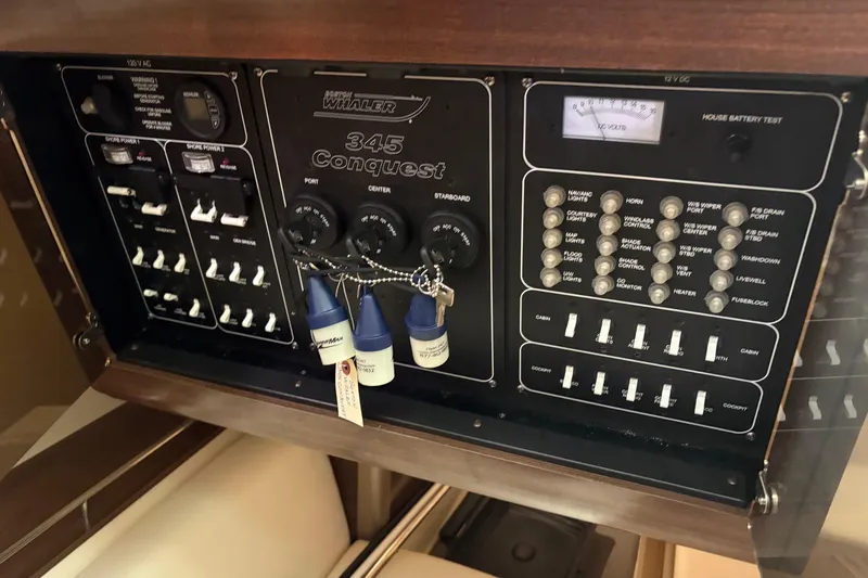 Slide: The Image of Control panel of a 2018 Boston Whaler 345 Conquest boat, featuring various switches and gauges. - 18