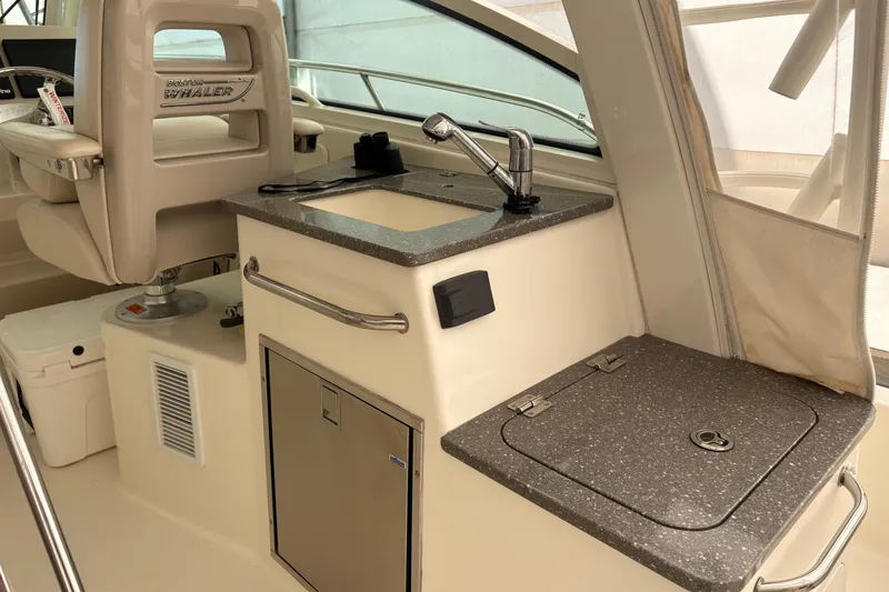 Slide: The Image of 2018 Boston Whaler 345 Conquest interior with sink and seating area. - 22