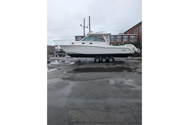 Slide: The Image of 2018 Boston Whaler 245 Conquest boat on a trailer in an industrial area. - 3