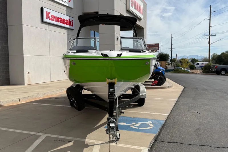 Slide: The Image of 2022 Yamaha Boats 212XD in green, parked outside a dealership. - 11