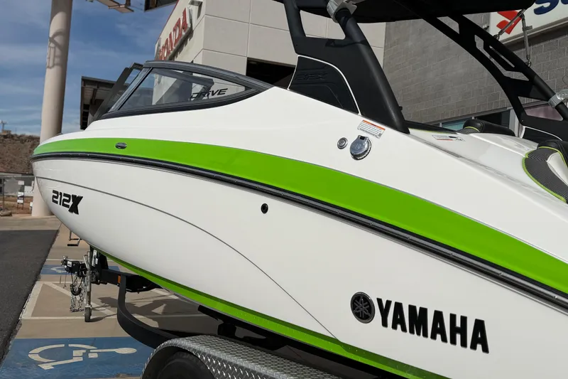 Slide: The Image of 2022 Yamaha Boats 212XD with green accents, displayed outdoors on a trailer. - 16