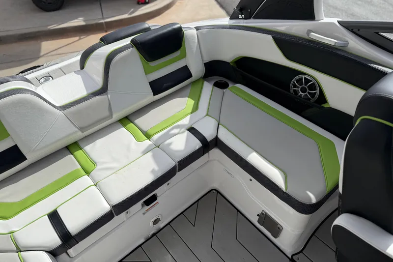 Slide: The Image of 2022 Yamaha Boats 212XD interior with green and white seating, speaker, and cup holder. - 26