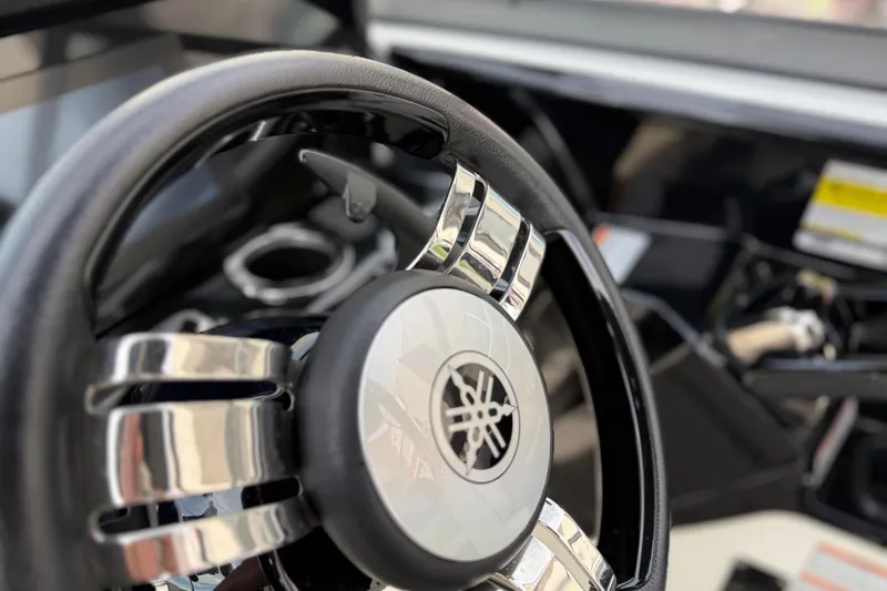 Slide: The Image of Steering wheel of 2022 Yamaha Boats 212XD, featuring sleek chrome accents. - 38