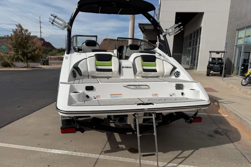 Slide: The Image of 2022 Yamaha Boats 212XD, rear view, parked outdoors with swim platform and ladder. - 5
