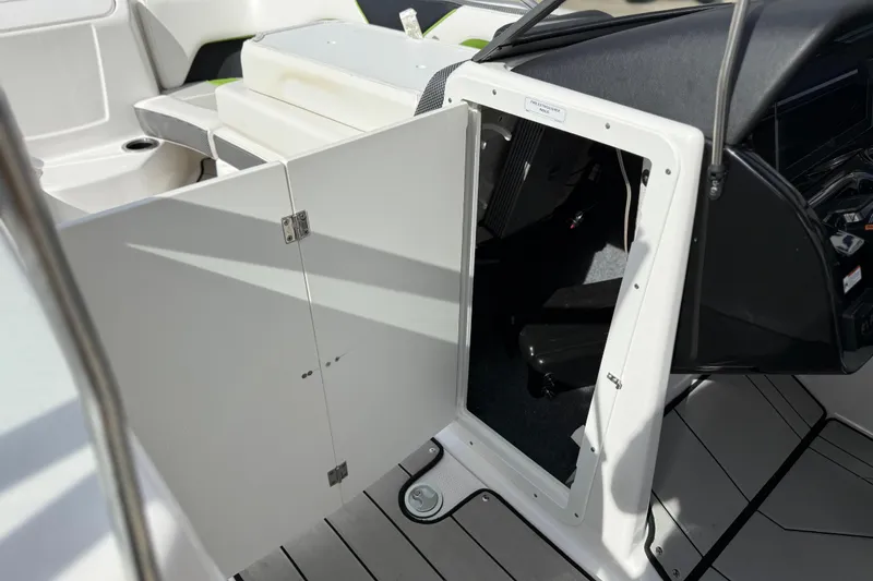 Slide: The Image of 2022 Yamaha Boats 212XD interior storage compartment with open door, showcasing sleek design. - 51