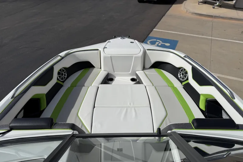 Slide: The Image of 2022 Yamaha Boats 212XD bow seating area with green accents and speakers. - 56