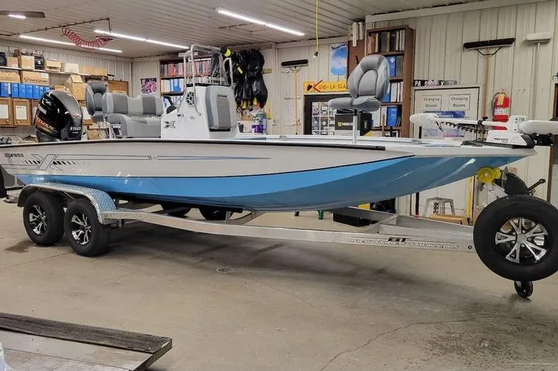 The Image of 2026 Xpress H20B Bay boat in a garage, featuring a sleek design and modern equipment. - 1
