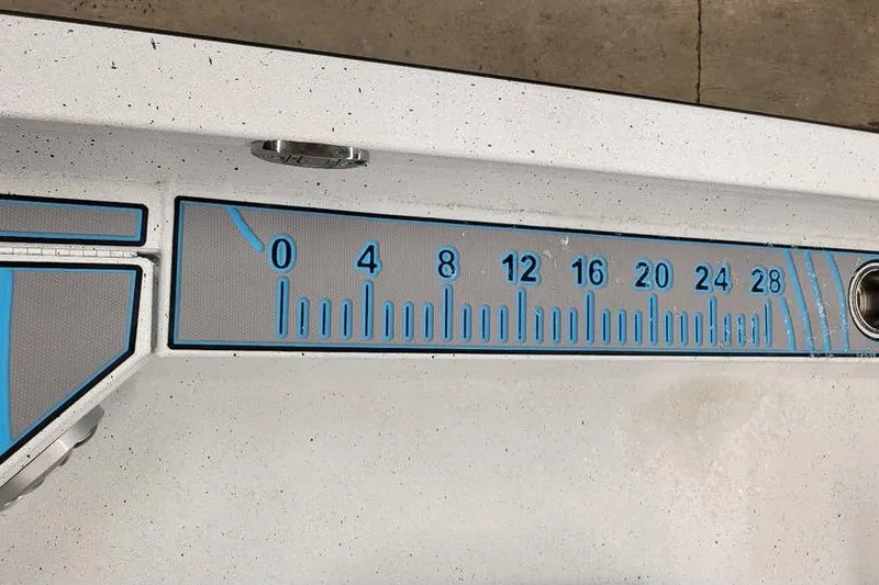 Slide: The Image of Ruler on 2026 Xpress H20B Bay boat deck, marked in blue increments. - 19