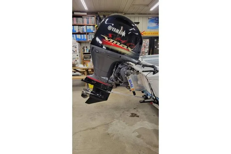 Slide: The Image of 2026 Xpress H20B Bay boat with Yamaha VMAX outboard motor in a workshop setting. - 6