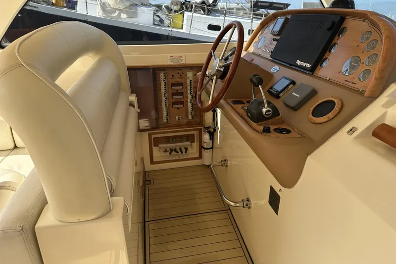 Slide: The Image of Helm of 2007 Mochi Craft 44 Dolphin yacht with wooden steering wheel and navigation controls. - 11