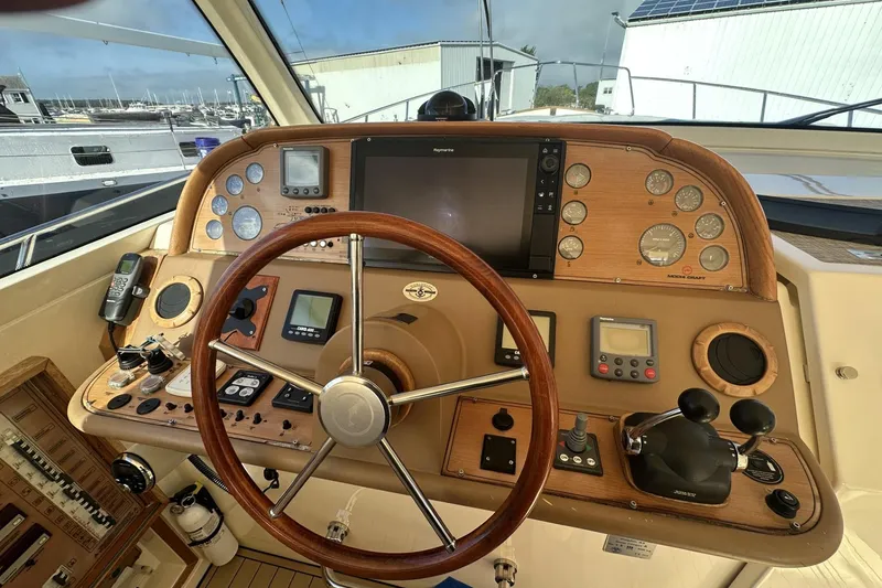 Slide: The Image of 2007 Mochi Craft 44 Dolphin yacht helm with wooden dashboard and navigation instruments. - 13