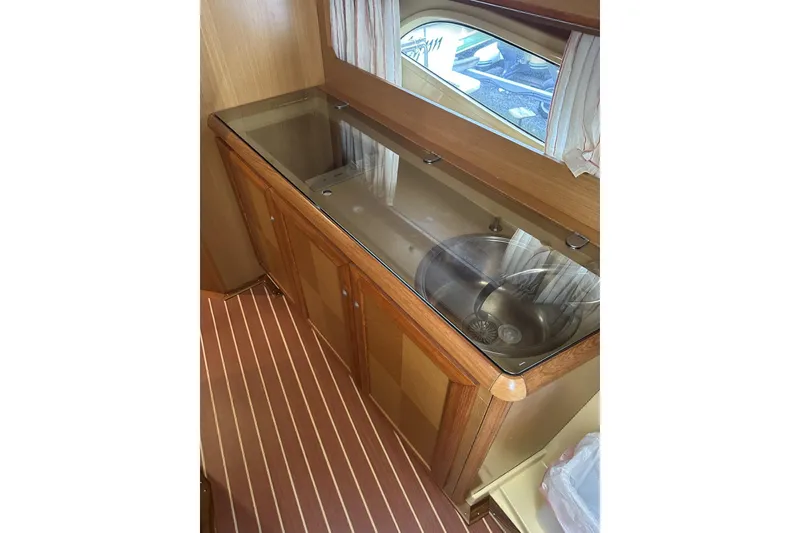 Slide: The Image of 2007 Mochi Craft 44 Dolphin yacht interior with wooden cabinetry and stainless steel sink. - 16