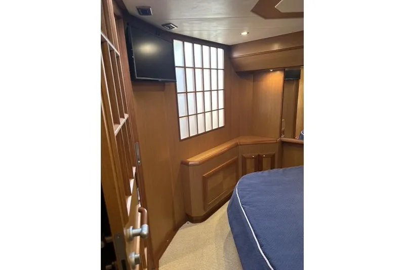 Slide: The Image of Interior of 2007 Mochi Craft 44 Dolphin yacht, featuring wood paneling and a mounted TV. - 19