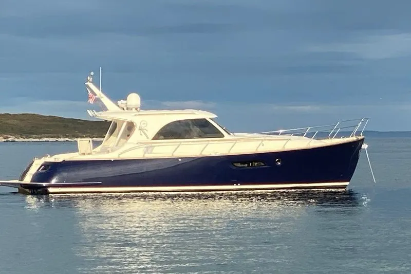 The Image of 2007 Mochi Craft 44 Dolphin yacht on calm water under cloudy sky. - 2