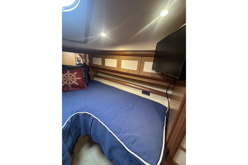 Slide: The Image of Cozy cabin interior of 2007 Mochi Craft 44 Dolphin with blue bedding and nautical decor. - 25
