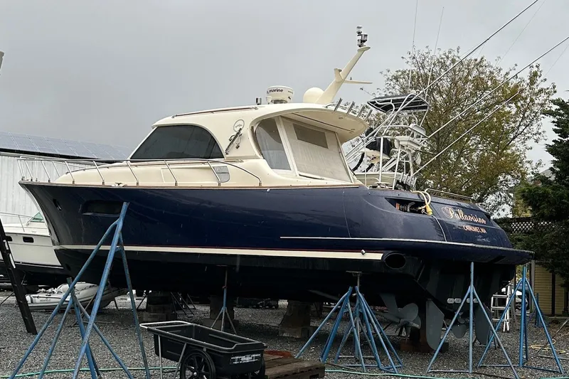 Slide: The Image of 2007 Mochi Craft 44 Dolphin yacht on stands, blue hull, outdoor storage. - 32