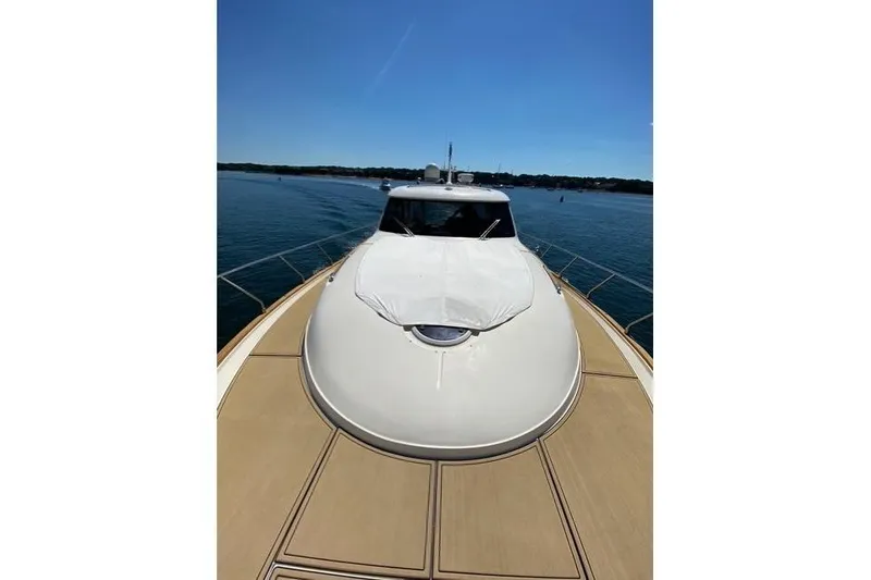 Slide: The Image of 2007 Mochi Craft 44 Dolphin yacht on calm water, showcasing sleek design and spacious deck. - 5