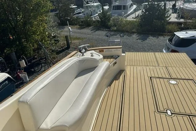 Slide: The Image of 2007 Mochi Craft 44 Dolphin yacht with teak deck and white seating, docked near other boats. - 7